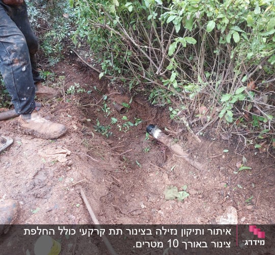אדם עובד על צינור מים באדמה עם מפתח צינורות